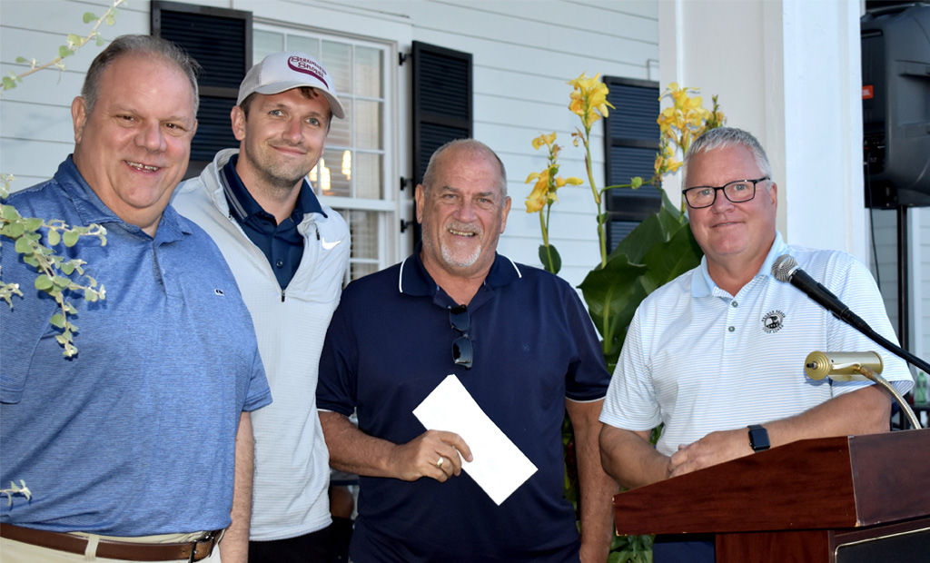 Four individuals at the golf tournament